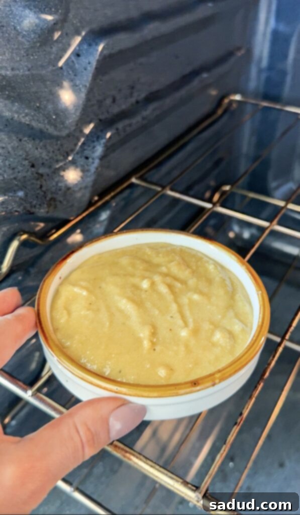 Mug cake baking in the oven, showing golden brown edges.