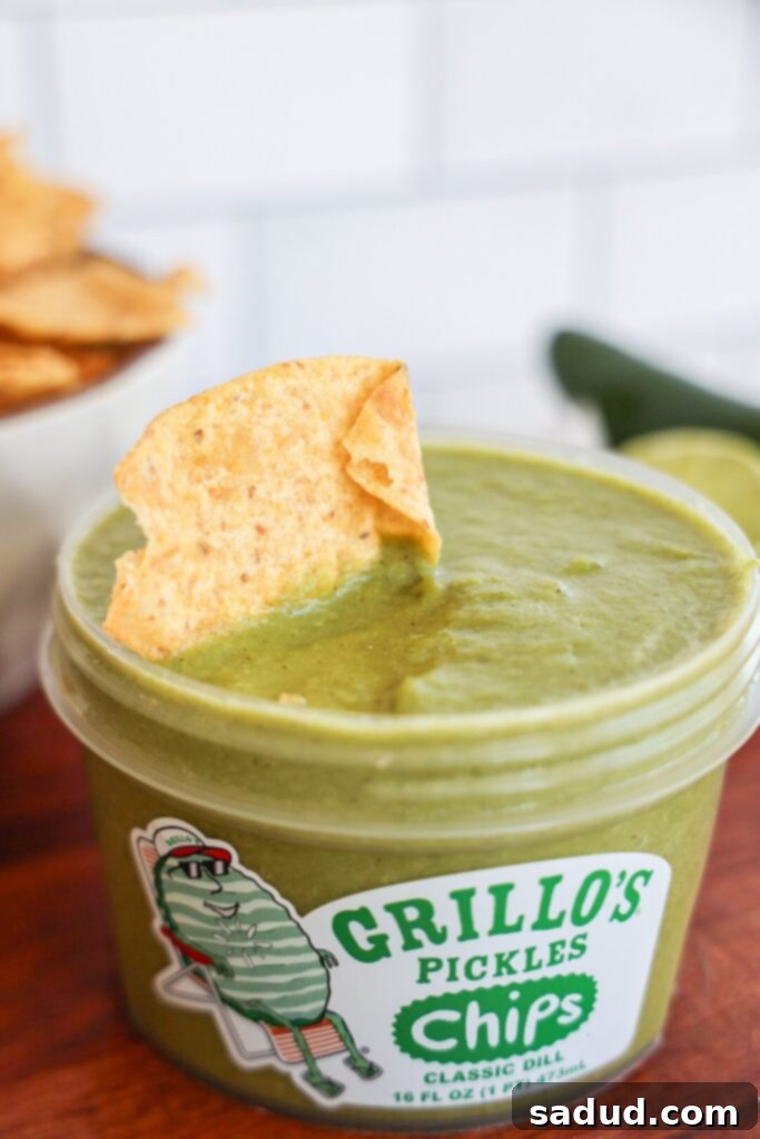 Dill pickle salsa served in a bowl with tortilla chips