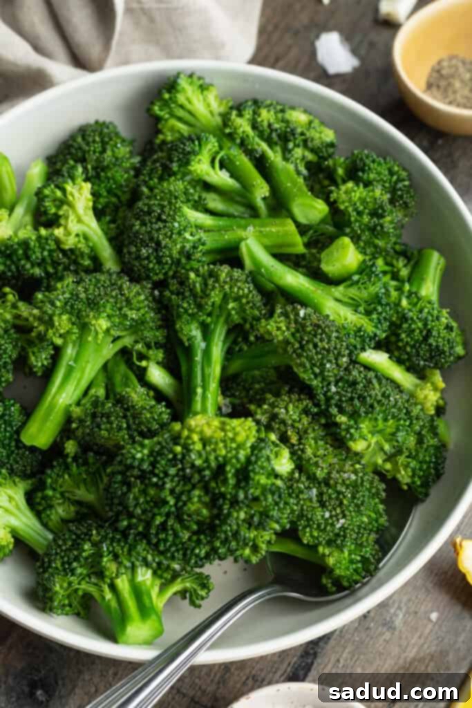 Silky Sous Vide Broccoli Florets 2 Overhead view of a bowl of sous vide broccoli on a dark tabletop, showcasing its vibrant green color.