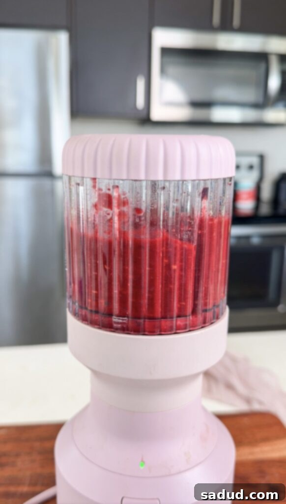Step-by-step image of blending raspberries for marshmallows.