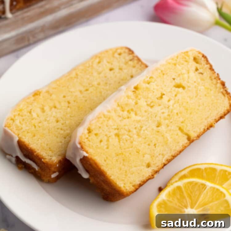 Irresistible Gluten-Free Lemon Cake 4 Two perfectly sliced pieces of gluten-free iced lemon pound cake arranged on a white plate, garnished with fresh lemon slices.