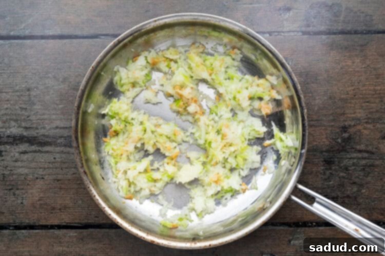 Irresistible Vegan Empanadas 9 Large skillet with empanada filling ingredients on a wooden background.
