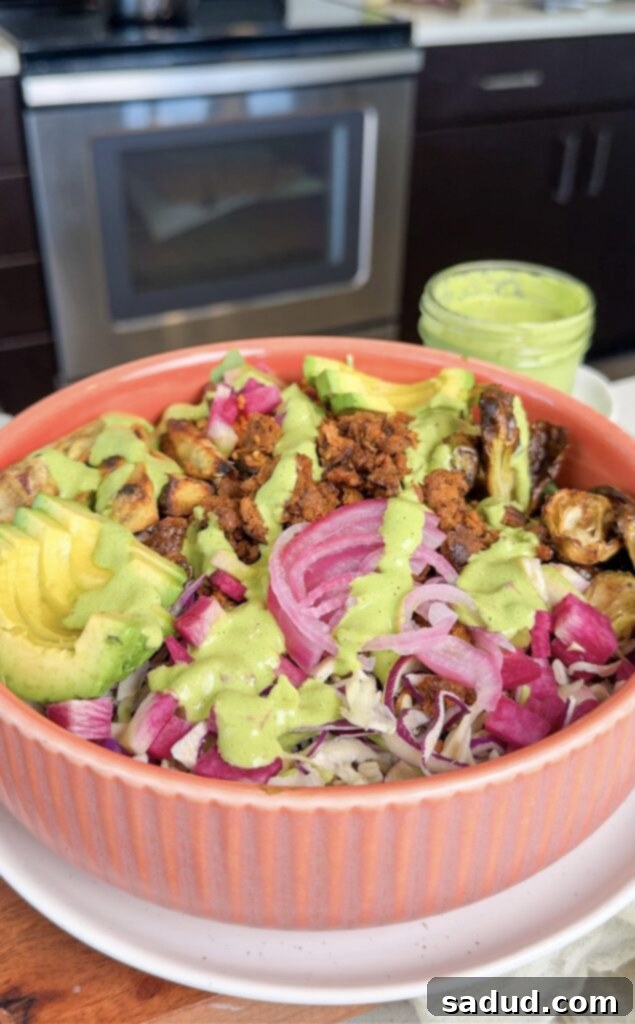 Healthy nourish buddha grain bowl with green herb tahini sauce.