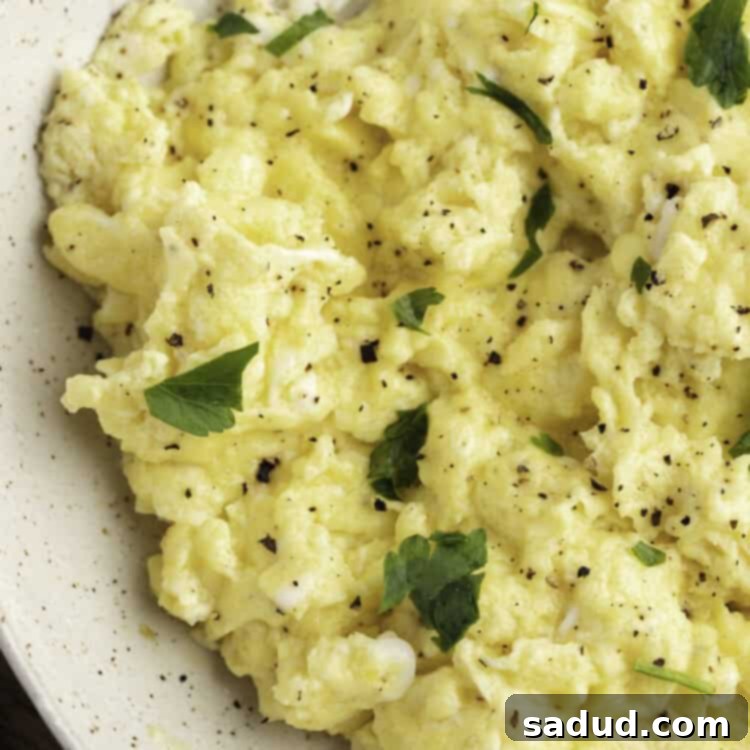 Fluffy Instant Pot Scrambled Eggs 4 Overhead close-up view of Instant Pot scrambled eggs in a large white bowl with fresh garnish, ready to serve.