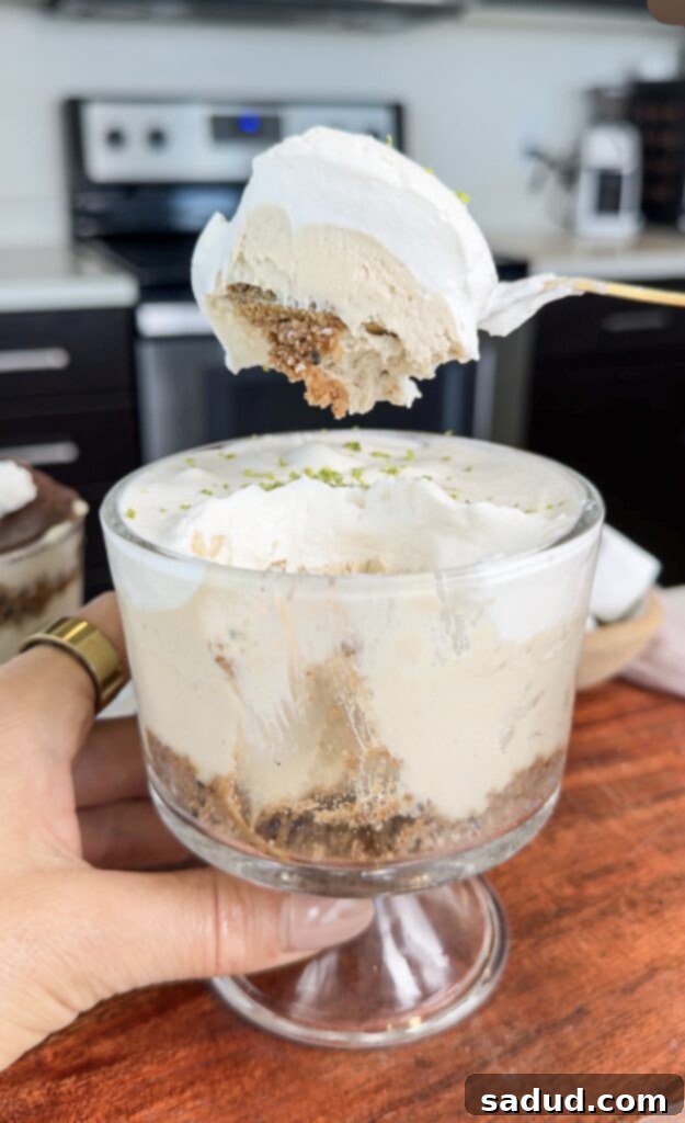 Individual no-bake paleo key lime pies in glass jars, topped with coconut whipped cream and lime zest.