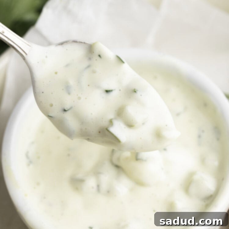 A small white ramekin filled with creamy vegan tartar sauce, with a silver spoon scooping a portion. Perfect for dipping!