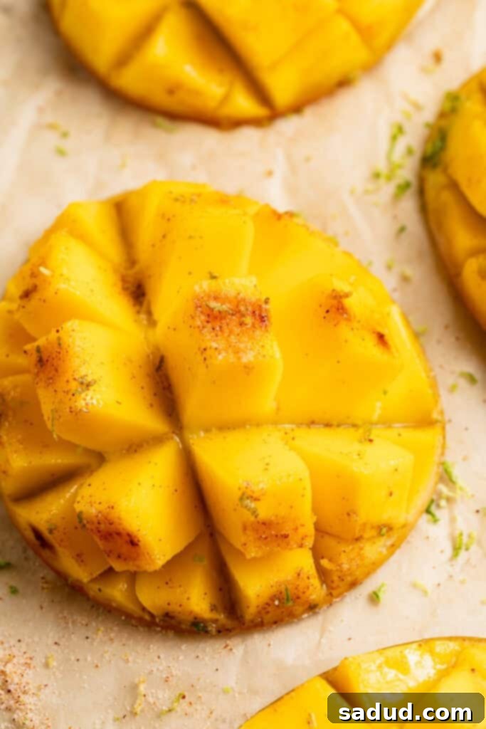 Close-up view of a cubed, grilled mango on a sheet of parchment paper.