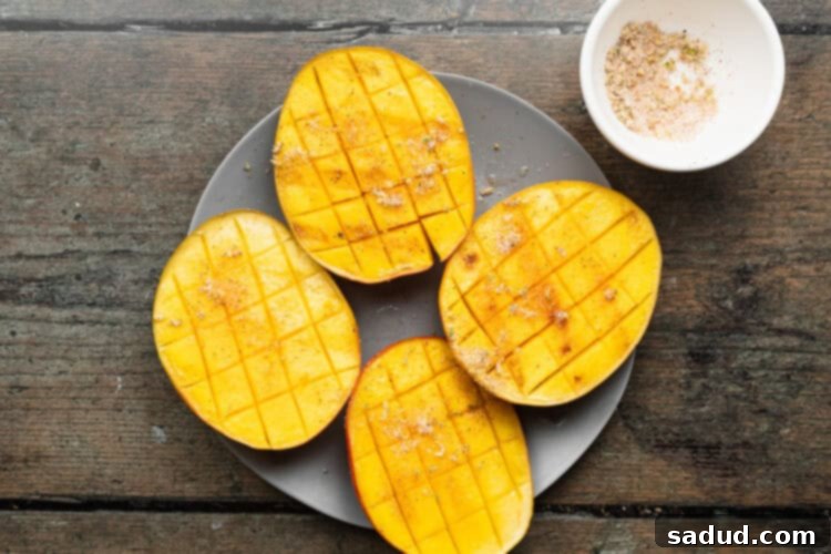 Grilled mango with chili-lime salt and fresh lime juice on a plate on a wooden table.