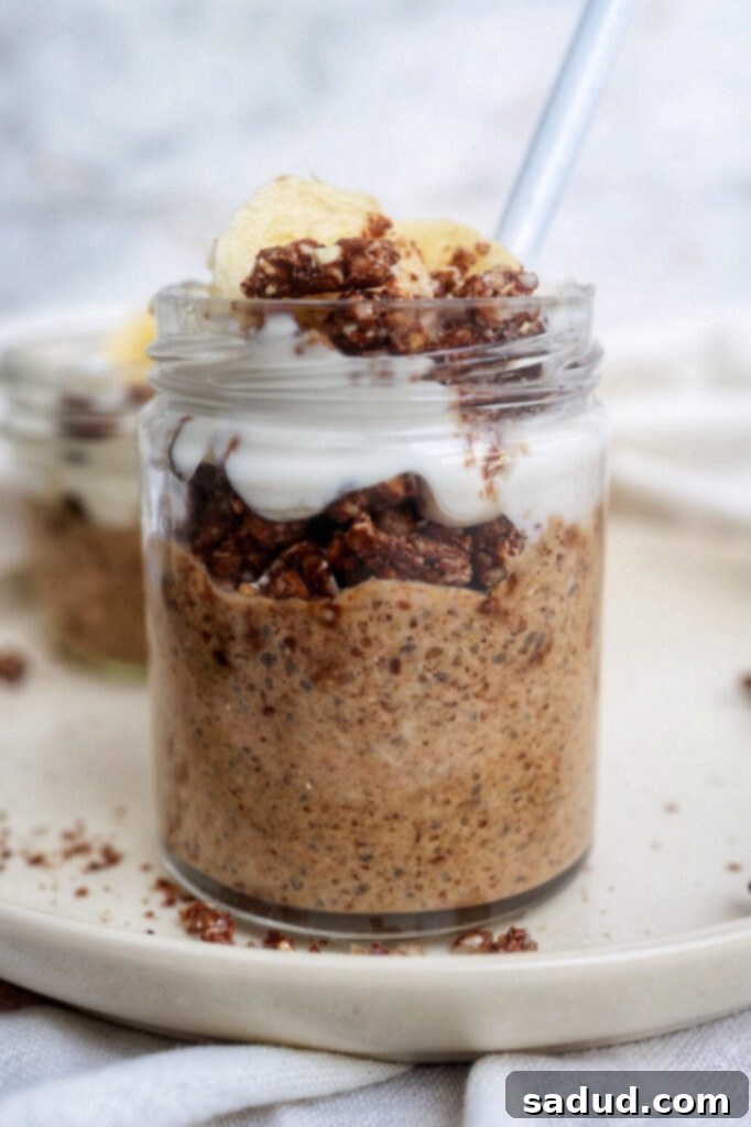 A jar of sweet potato chia pudding layered with granola and fresh fruit, ready for a healthy and satisfying breakfast. The vibrant orange hue of the pudding contrasts beautifully with the toppings.