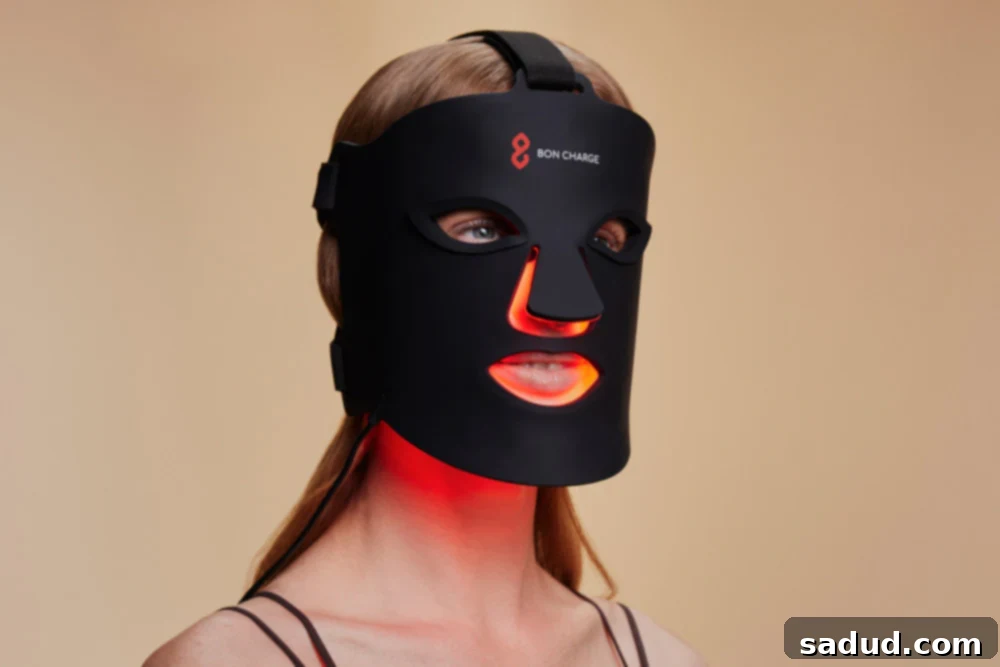 Woman relaxing with a red light face mask on, promoting self-care.