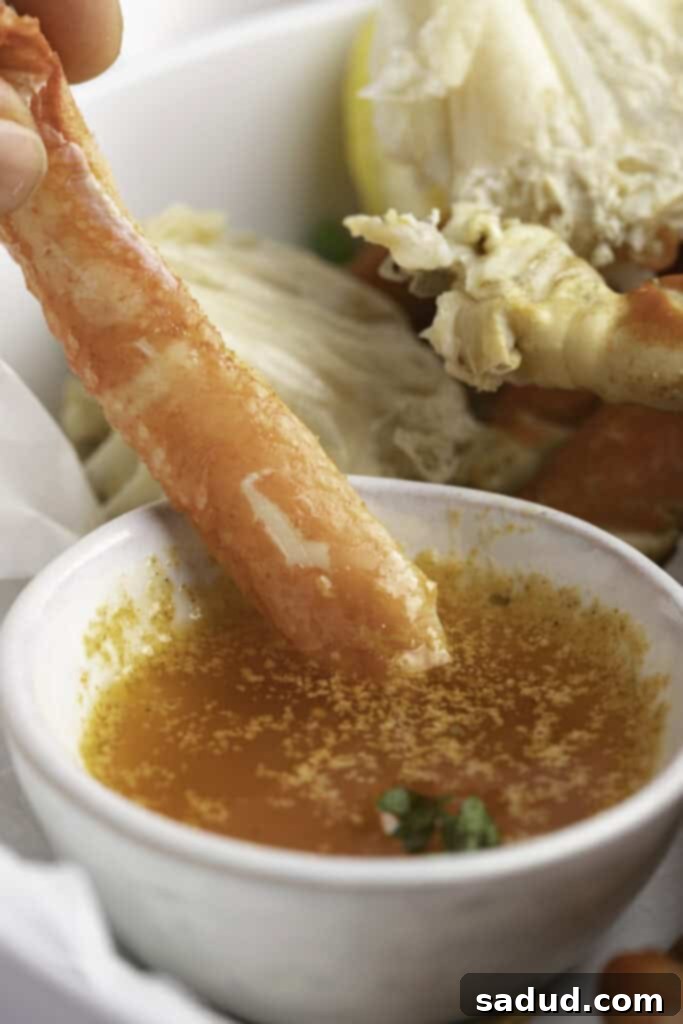 Instant Pot crab legs dipped in a garlic butter sauce.