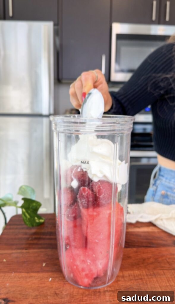 A close-up shot of fresh strawberries, lime wedges, and a slice of watermelon, highlighting the key ingredients for the smoothie.
