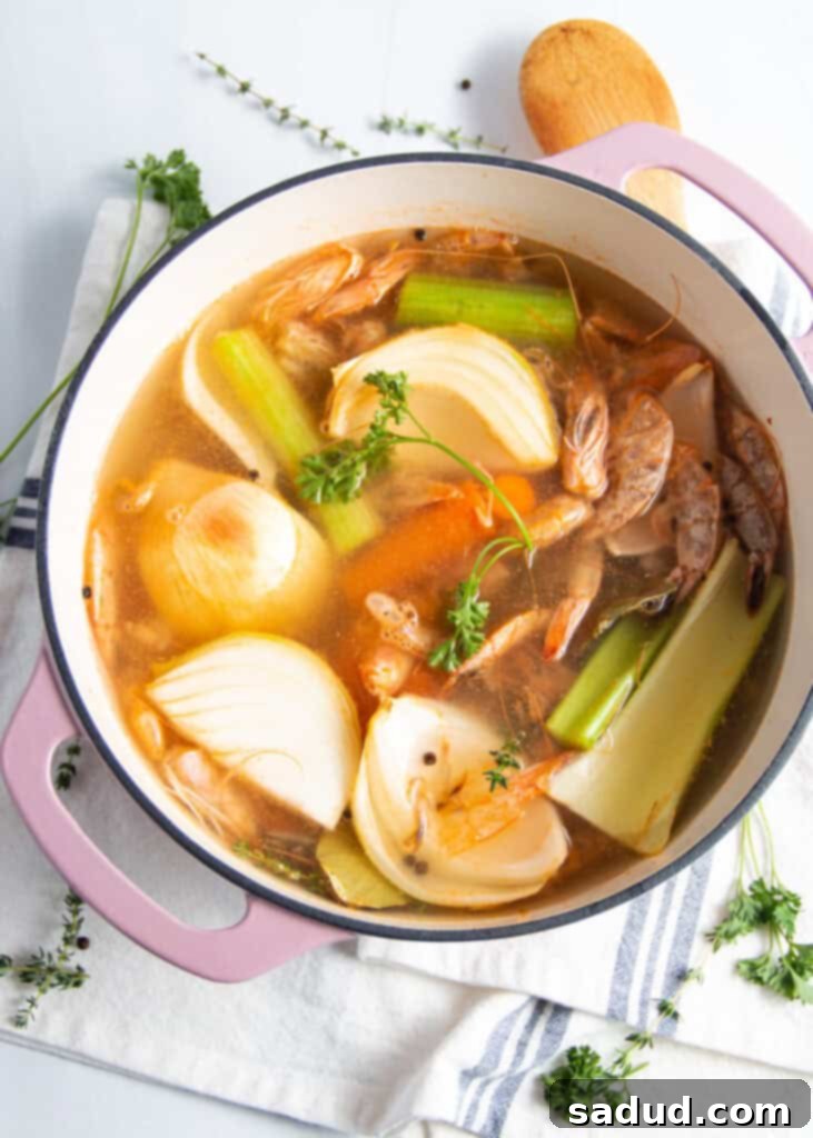 Overhead view of ingredients for shrimp stock in a large, heavy-bottomed stock pot.