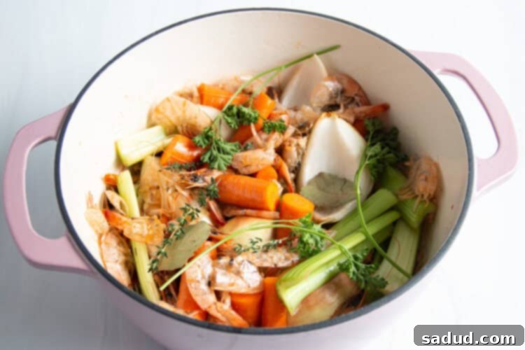 Overhead view of all shrimp stock ingredients in large dutch oven.