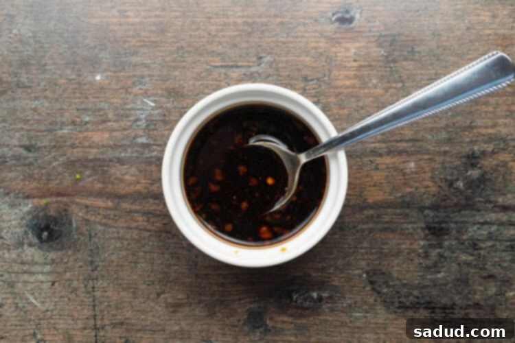 Overhead view of a prepared dipping sauce for air fryer dumplings in a small ramekin on a wooden table.