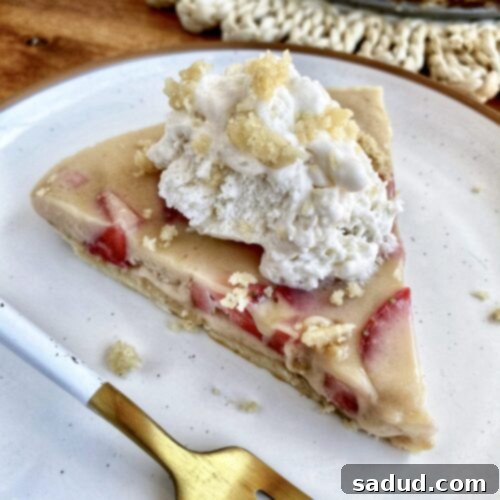 A top-down view of the whole No-Bake Strawberry Shortcake Tart, garnished with coconut whip and toasted coconut flakes.