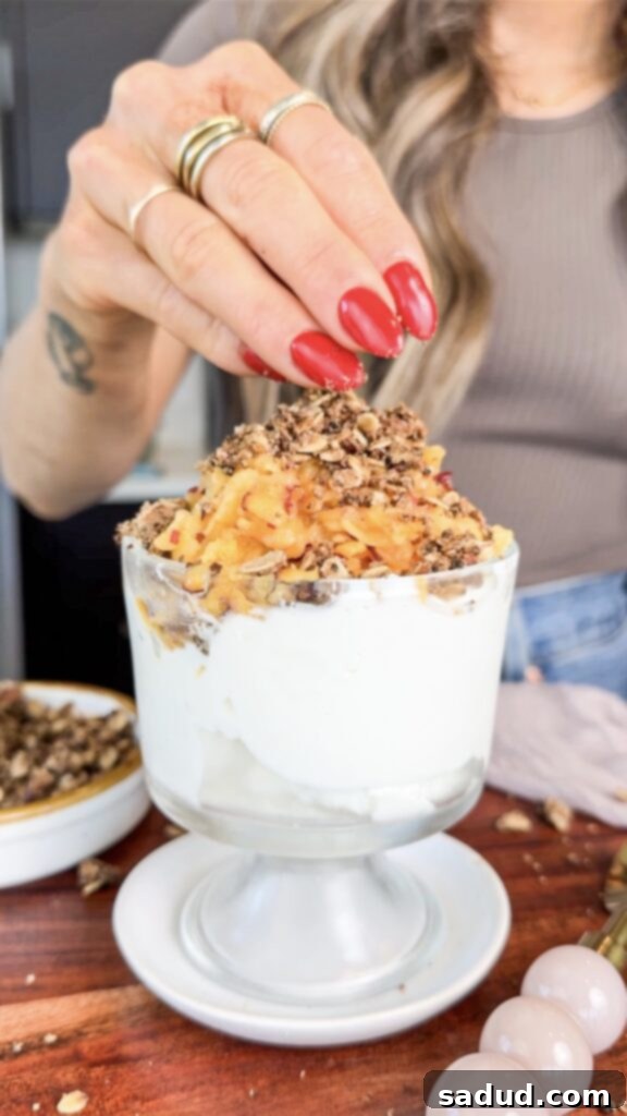 A completed healthy frozen peach crisp parfait, garnished and ready to enjoy.