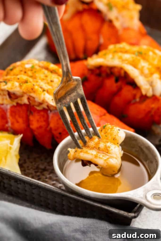 A succulent piece of Instant Pot lobster tail meat on the end of a fork, being dipped into a small ramekin of golden drawn butter.