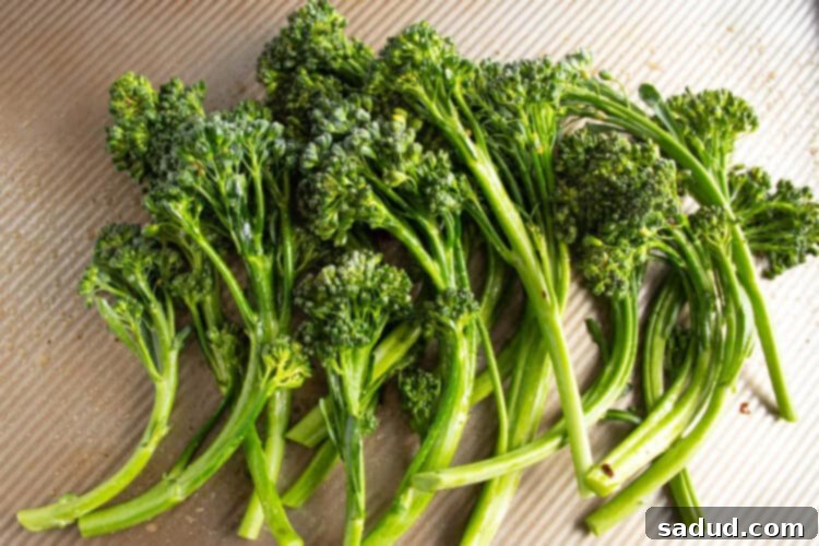 Trimmed broccolini on a cutting board, ready for seasoning.