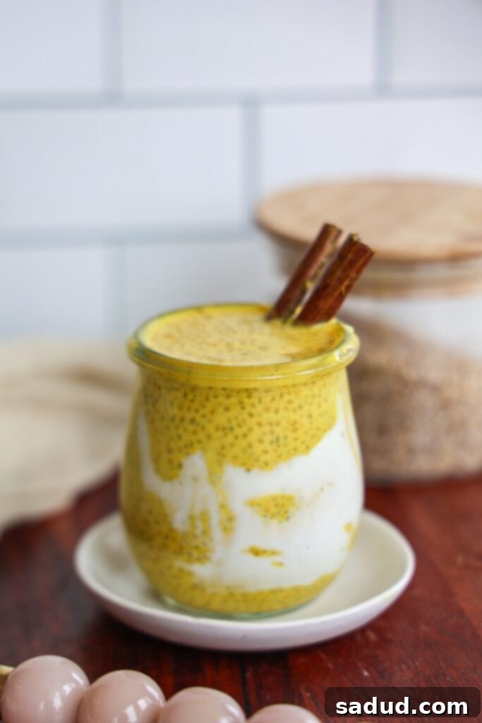 A close-up shot of golden milk chia pudding in a glass jar, showing its layered texture and appealing color.