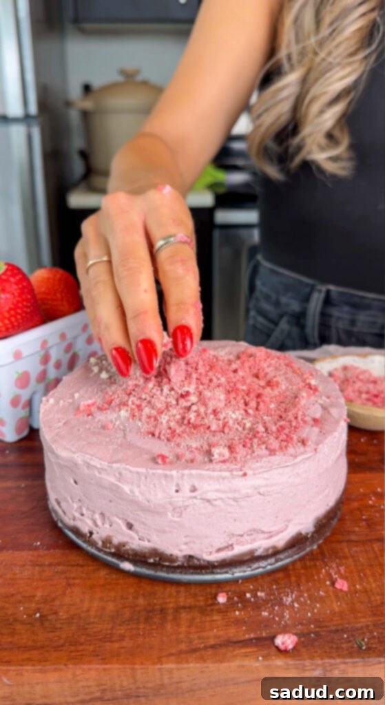 Assembling the no-bake vegan strawberry cheesecake in a springform pan.
