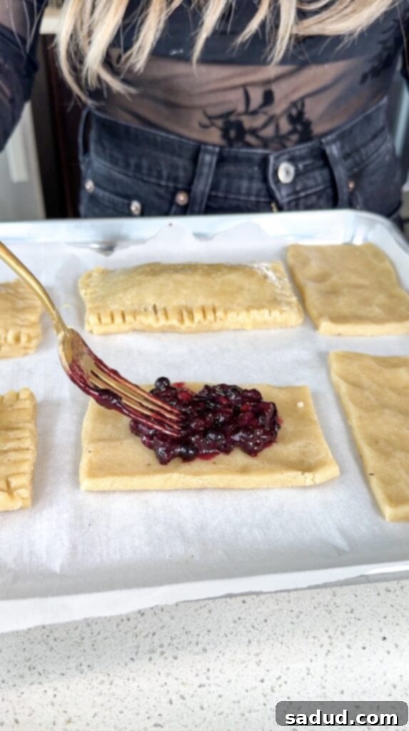 Blueberry filling being placed on dough rectangles.