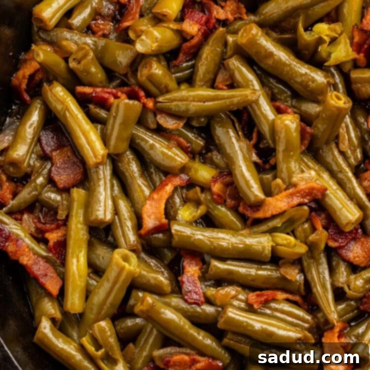 A close-up shot of Texas Roadhouse-style green beans in a cast iron skillet, garnished with crispy bacon bits.