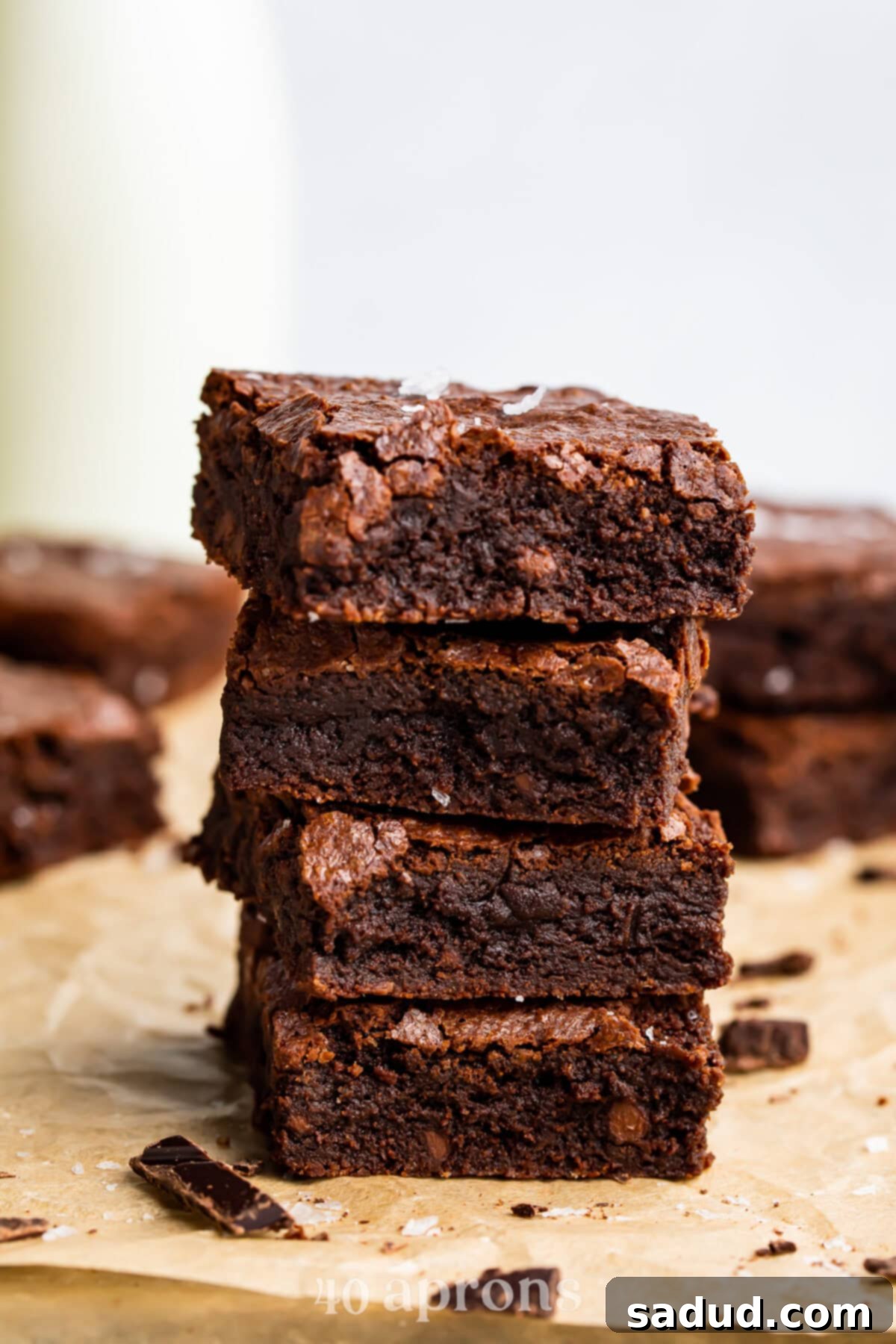 Decadent Dairy-Free Fudgy Brownies 2 Side view of fudgy dairy-free brownies stacked on top of each other showing their moist, rich interiors and shiny crackle top.