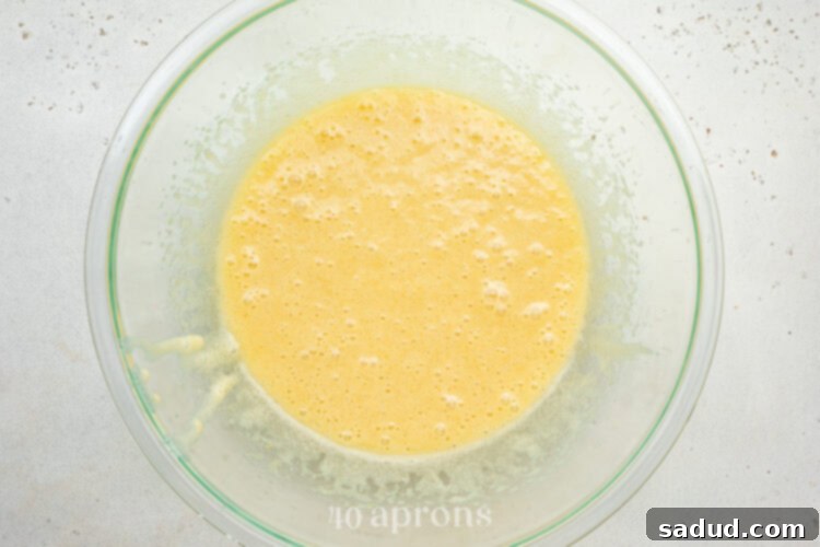 Wet ingredients for dairy-free brownies mixed with eggs to form a light, fluffy base.