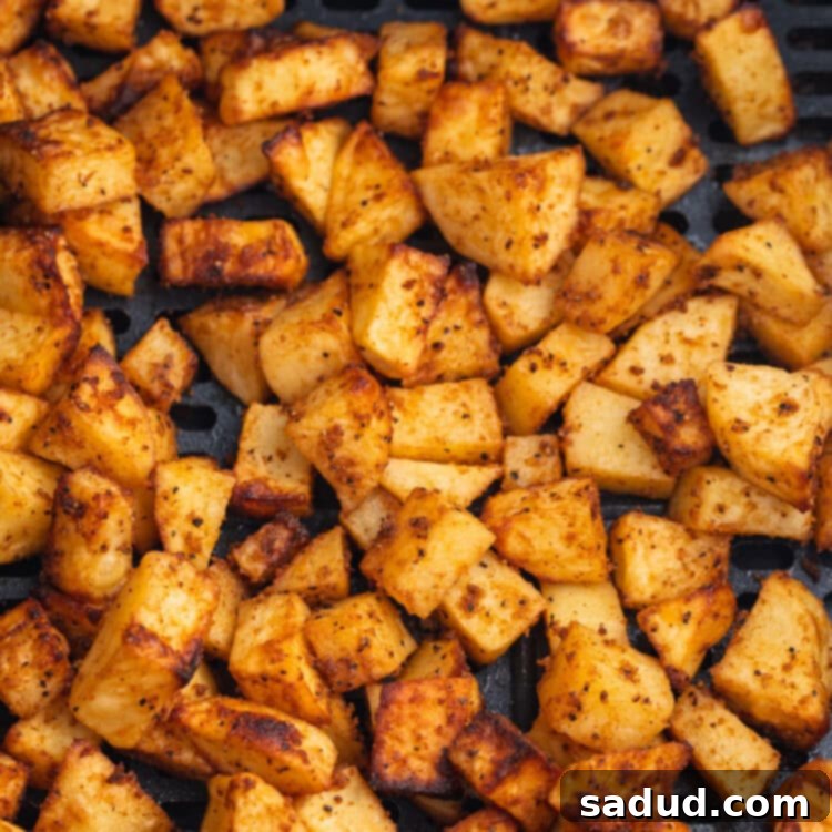 Crispy Air-Fried Morning Spuds 4 Overhead view of air fryer breakfast potatoes in an air fryer basket.