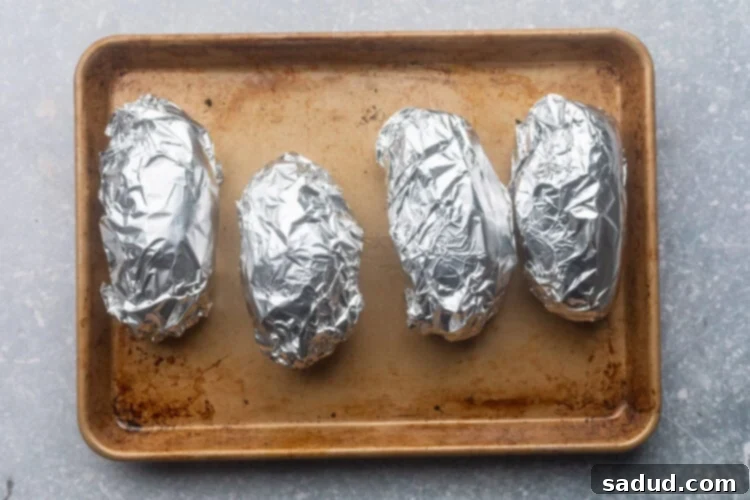Potatoes wrapped in foil, ready for baking.