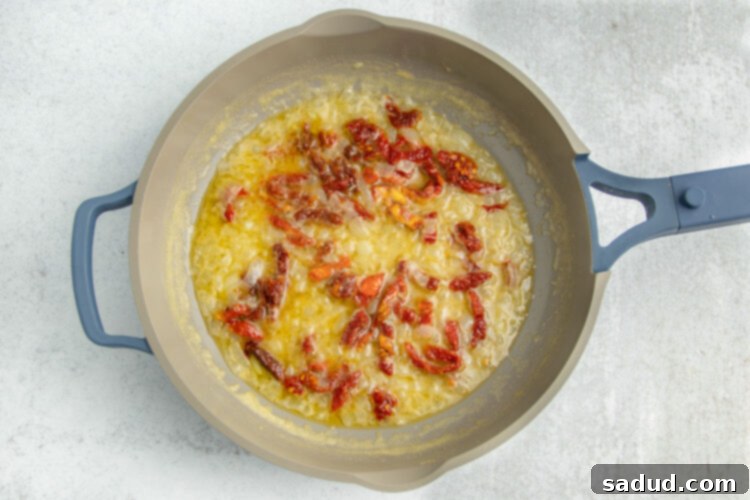 Melted butter with sun-dried tomatoes in a large skillet.