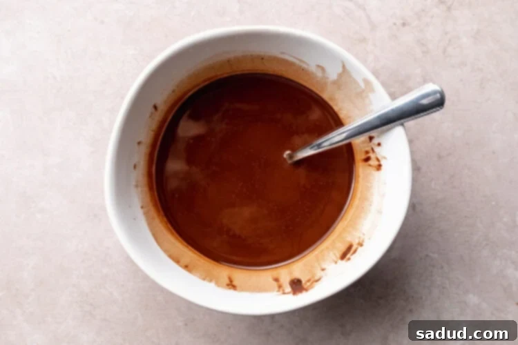 Melted chocolate and coconut oil in a microwave-safe mixing bowl.