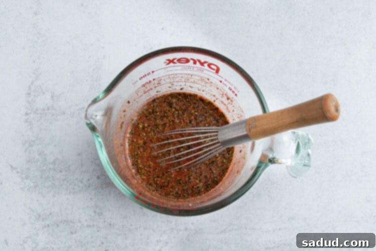 Achiote chicken sauce in glass measuring cup.