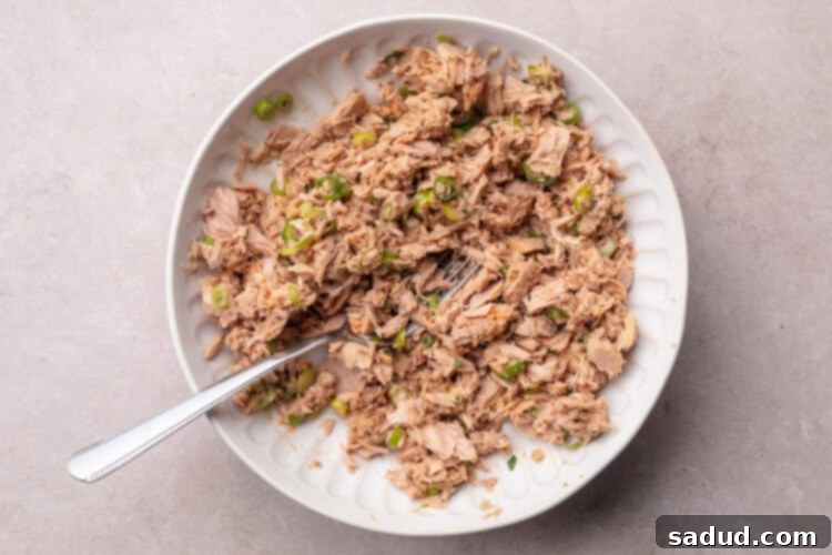 Seasoned flaked tuna for tuna tostadas in a large mixing bowl.