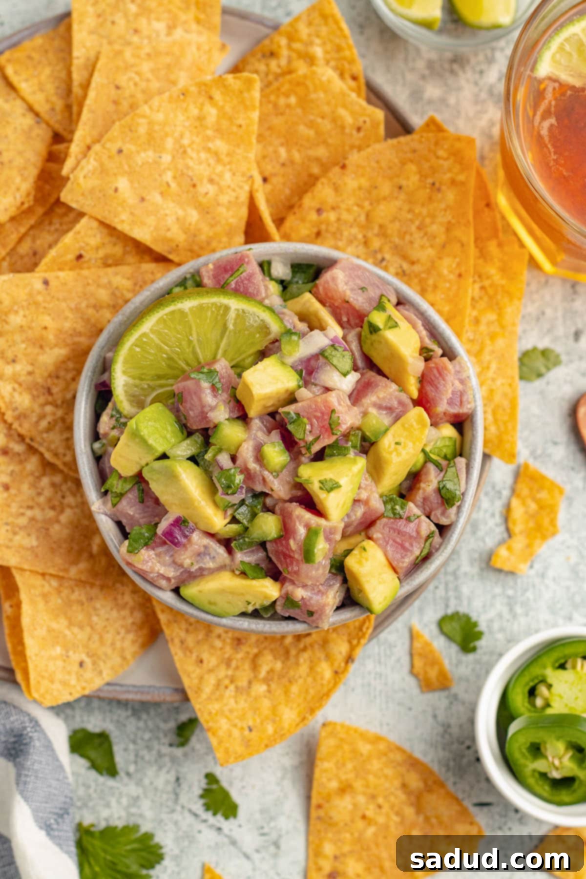 Zesty Tuna Ceviche 9 Overhead view of a bowl of tuna ceviche with chunks of ahi tuna, avocado, cilantro, and red onion with tortilla chips.