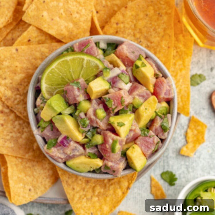 Zesty Tuna Ceviche 3 Overhead view of a bowl of tuna ceviche with chunks of ahi tuna, avocado, cilantro, and red onion with tortilla chips.