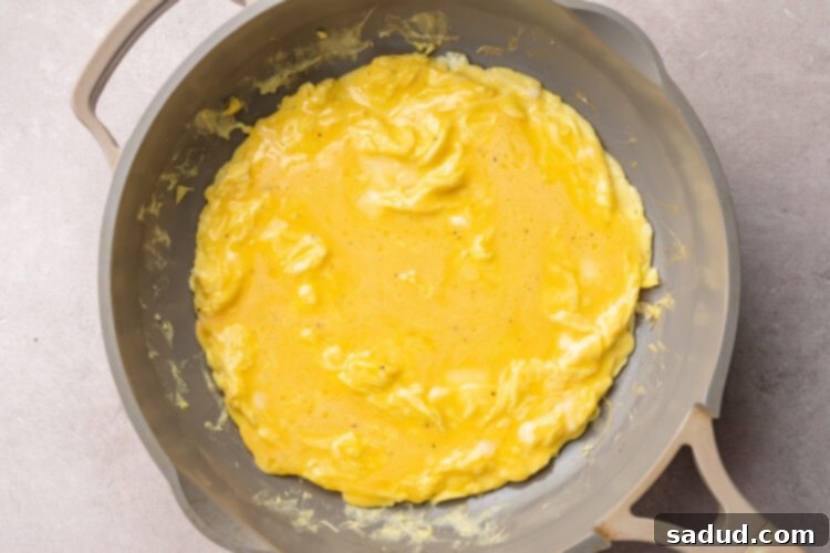 Scrambled eggs for a chicken omelette in a medium non-stick skillet.