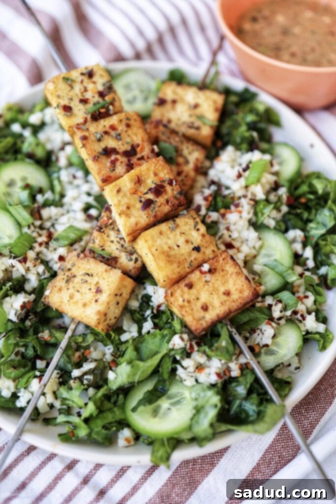 Crispy Tofu Peanut Satay Skewers served with fresh herbs.