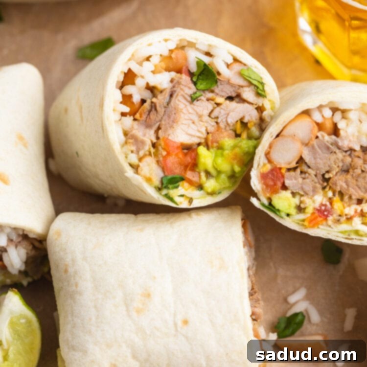 The Ultimate Carnitas Experience 4 Two carnitas burritos cut in half and laying on a sheet of parchment paper.