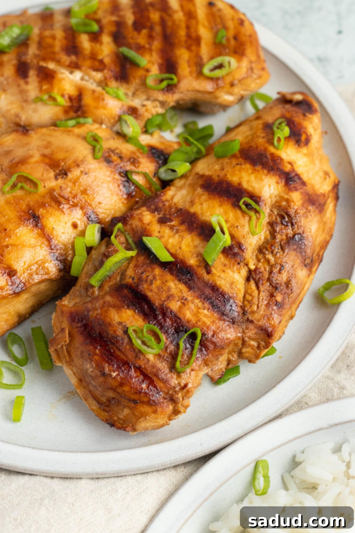 Grilled chicken adobo, sliced and arranged on a platter with rice.