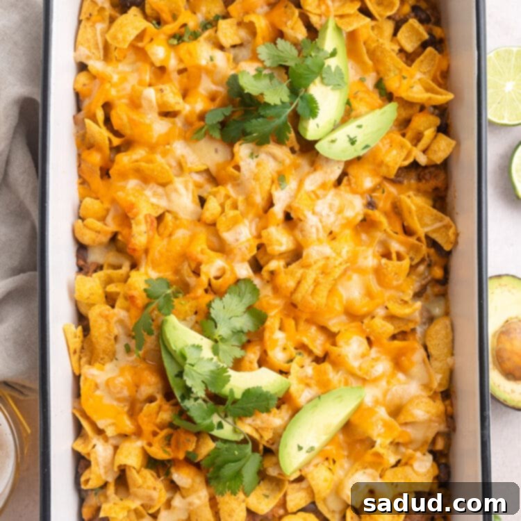 Loaded Taco Casserole 4 Walking taco casserole in a rectangular white casserole dish. A scoop is missing.