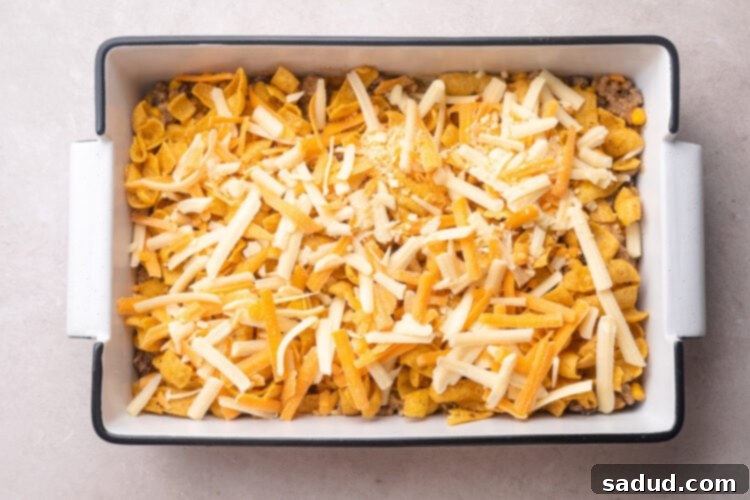Unbaked walking taco casserole in a 9x13 baking dish.
