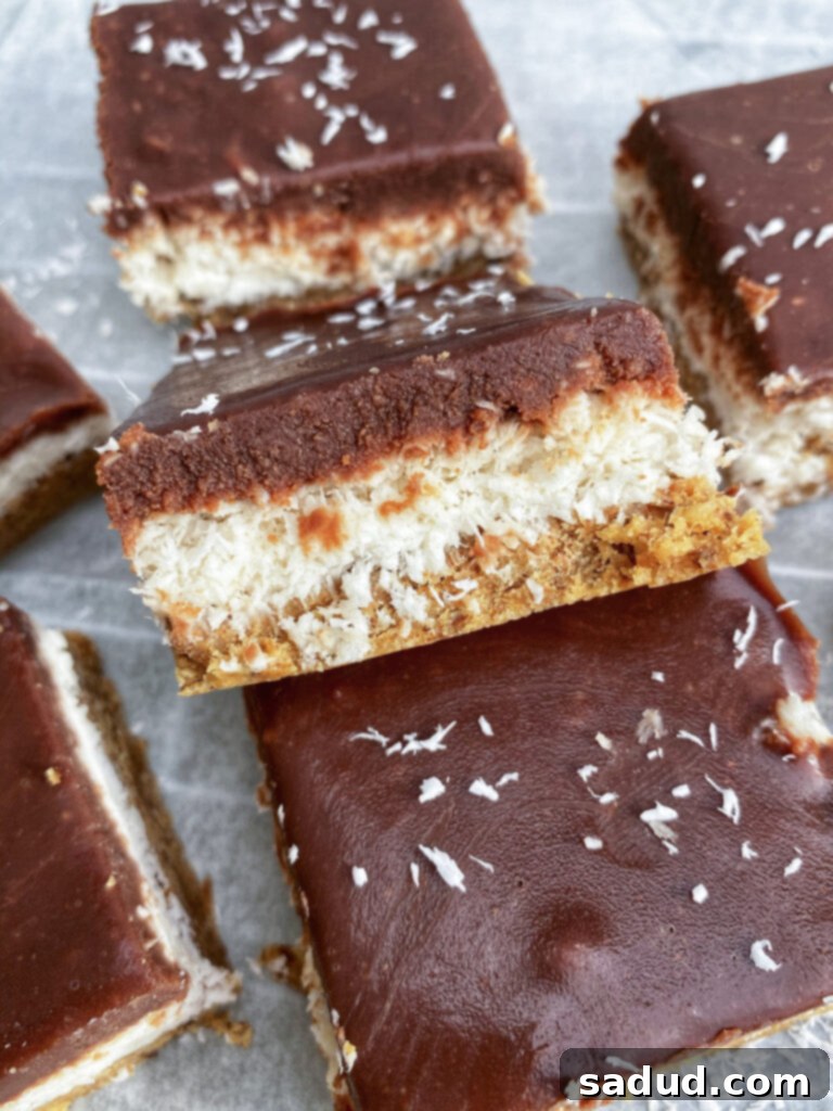 Vegan Chocolate Coconut Almond Delights 2 Vegan almond joy bars, showing a cross-section of the chocolate, coconut, and almond layers.