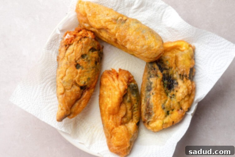 Fried peppers on a large white plate with paper towels.
