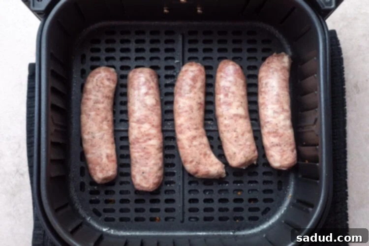 Crispy Air Fryer Italian Sausage 6 5 uncooked Italian sausage links in an air fryer basket.
