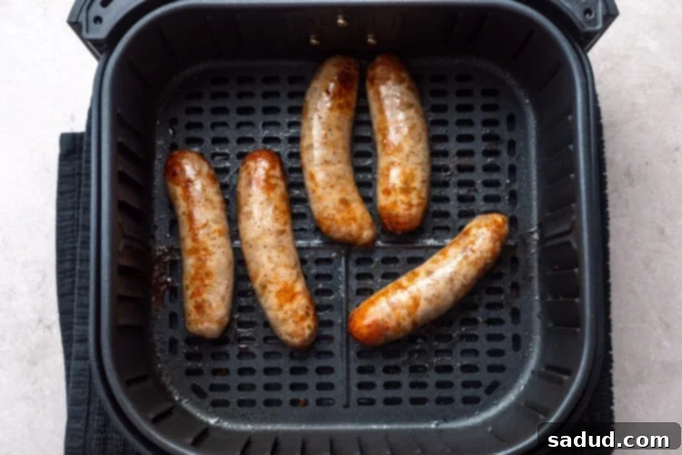 Crispy Air Fryer Italian Sausage 7 5 cooked Italian sausages in an air fryer basket.