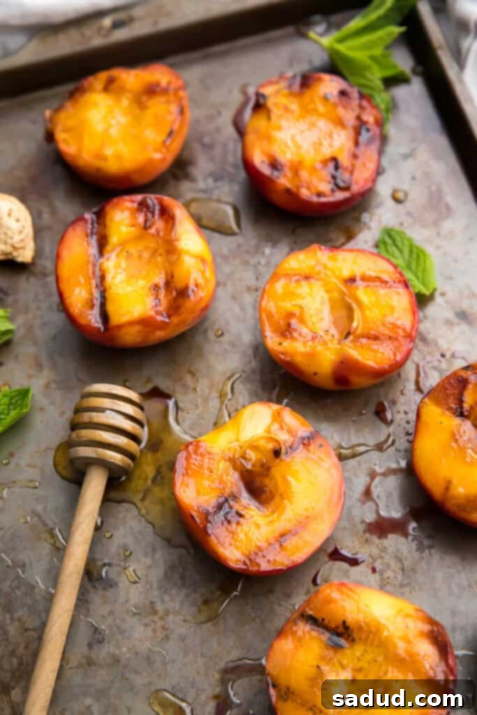 Freshly grilled peaches on a baking sheet, ready to be served