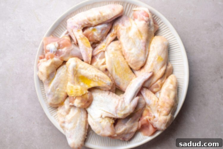 3 pounds of whole chicken wings piled on a round white plate.