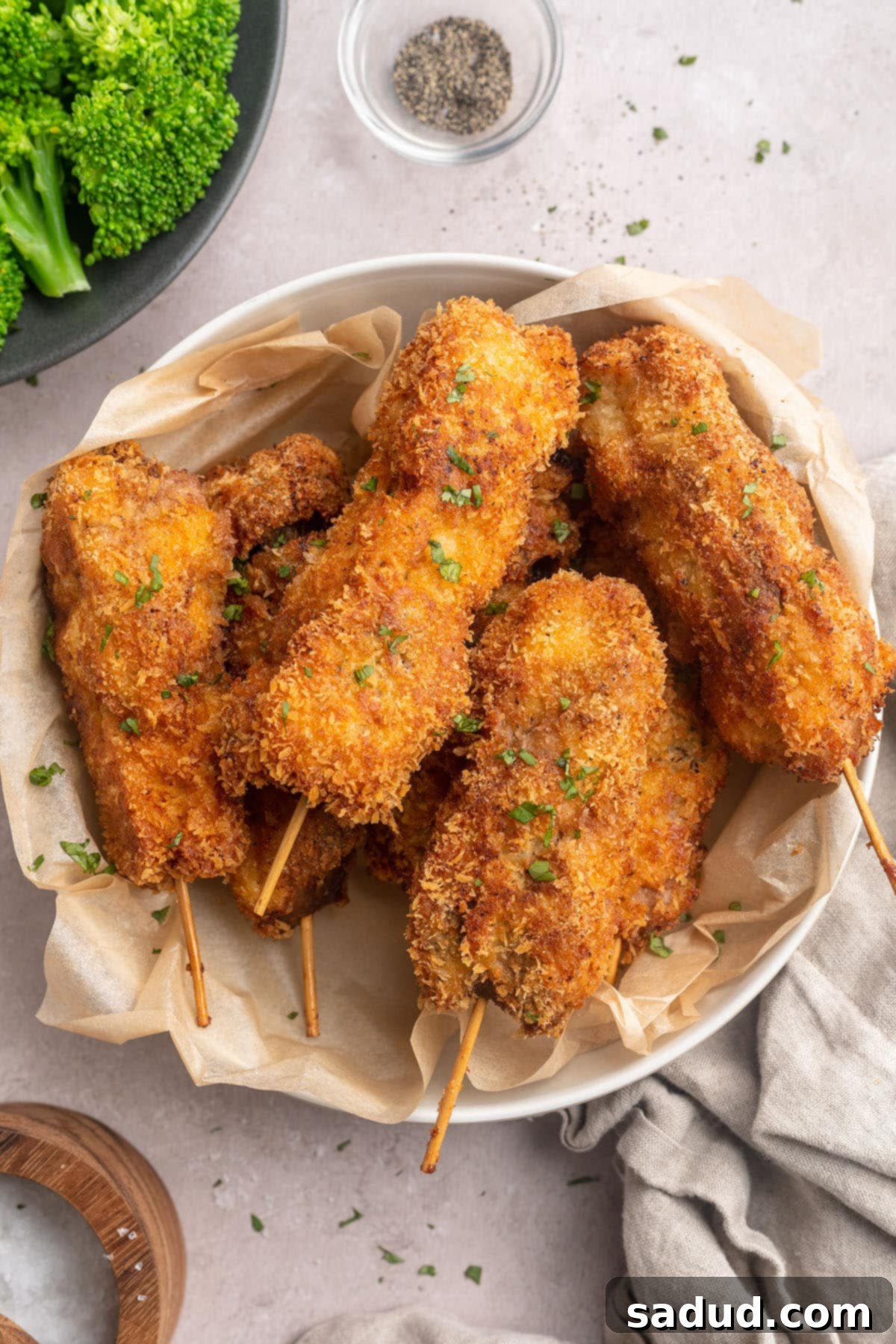 Two plates featuring delicious mock chicken legs, one with a side of creamy mashed potatoes and vibrant green broccoli, showcasing a complete and appetizing meal.